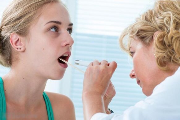Gydytojas tiria burnos ertmę, ar nėra papilomų